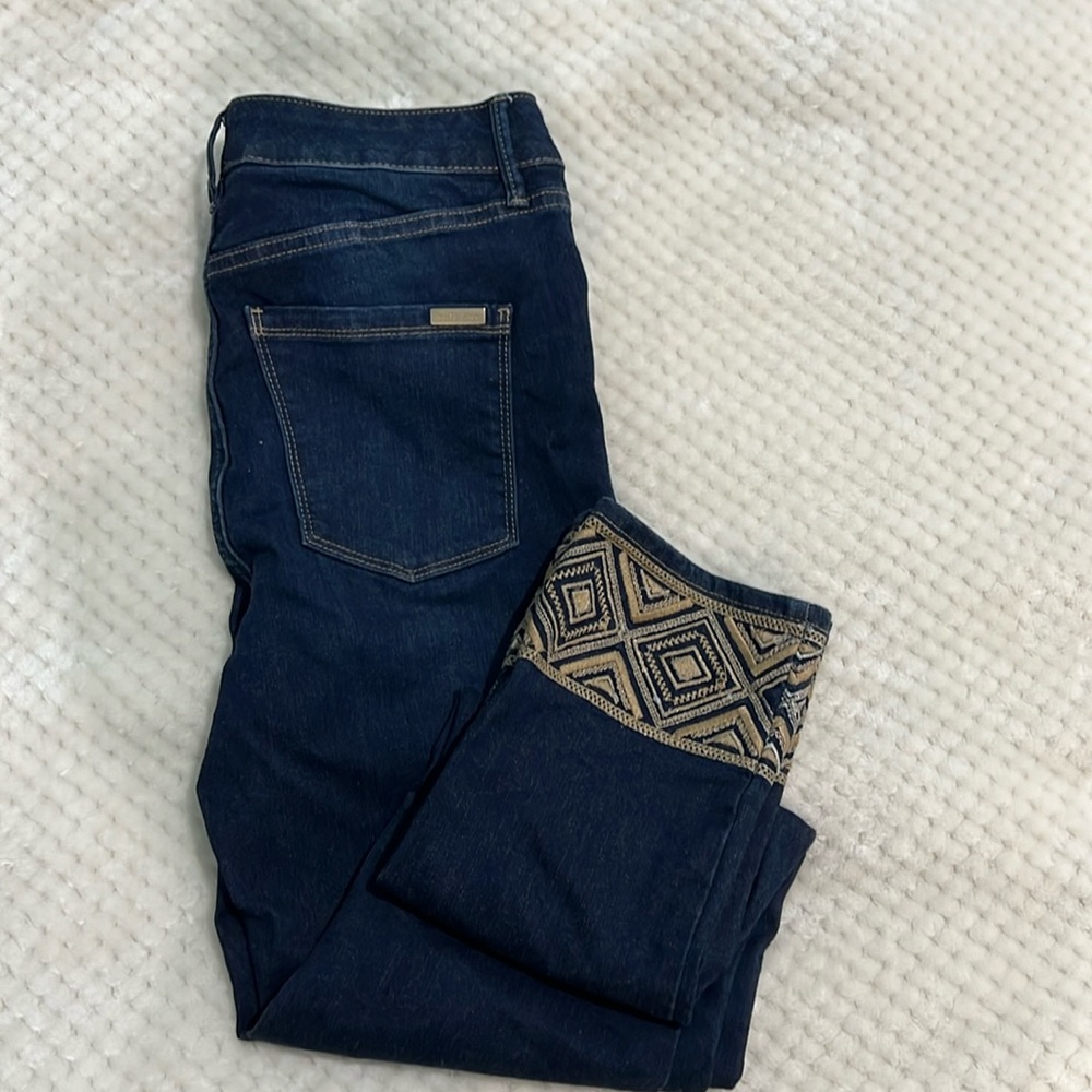 WHBM slim crop high rise jeans with gold colored embellishments on the ankle.